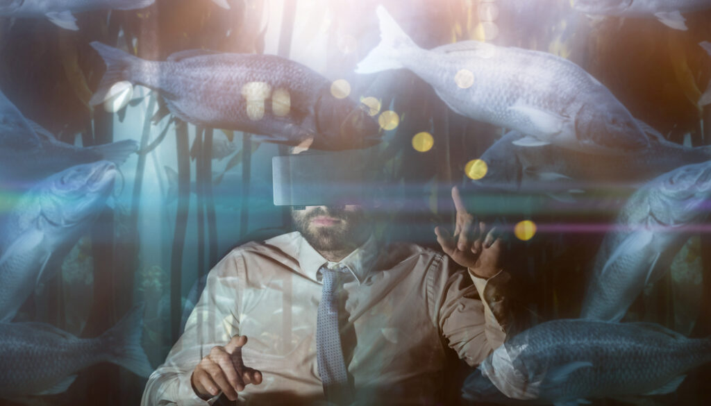 Big fish swimming in a tank against businessman using virtual reality device